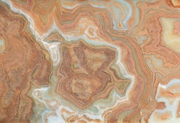 Onyx marble stone, crossed cut. Main colors are brown, orange, green and white. Texture and background.