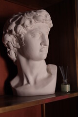 Plaster white head dummy depicting a woman stands on a table for interior decoration