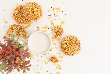 Broken rice cracker mixed grains topping with Nuts and White sesame seed with milk on white background. Healthy Snack, Top view. Copy space for text.