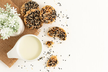 Broken rice cracker mixed grains topping with Black sesame seed and White sesame seed with milk on white background. Healthy Snack, Top view. Copy space for text.