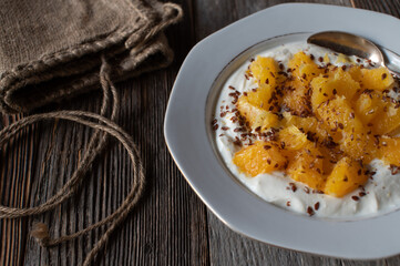 Fitness breakfast plate with high protein skyr, fresh chopped oranges and linseeds