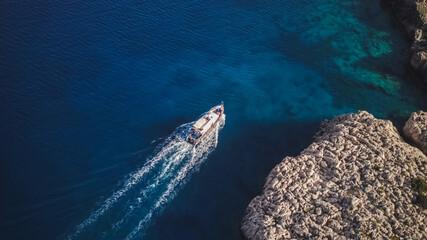 Top view from drone of speed boat in the blue water