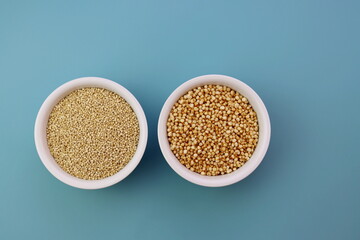 Grains of quinoa and quinoa popcorn in white round bowls on a blue background.