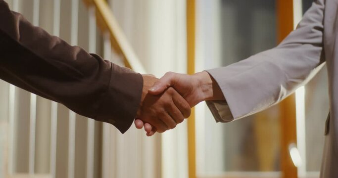 Two people shake hands, congratulating each other on a deal
