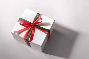 White gift box with red and green ribbon, christmas day present. A box for surprise in holiday.