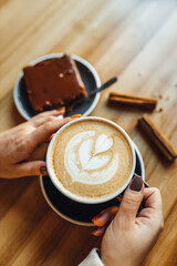 Women drinking Pumpkin spice latte at coffee shop; coffee and sweets on table. Seasonal coffe drinks