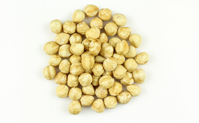 Pile of golden color roasted hazelnuts isolated on white background