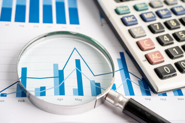 Magnifying glass and calculator on charts graphs paper. Financial development, Banking Account, Statistics, Investment Analytic research data economy, Stock exchange trading, Business office concept.