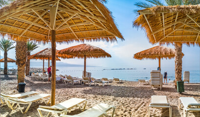 Morning at sandy beach of the Red Sea, panoramic view from central stone walking pier and promenade in Eilat - famous tourist resort city in Israel
