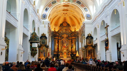 prunkvoller Innenraum der Basilika St. Anna in Altötting mit vielen Menschen beim Gottesdienst