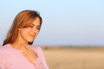 Fototapeta na wymiar Woman suffering sore throat in a field