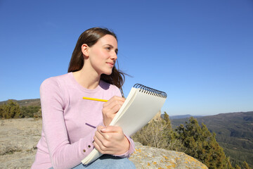 Woman drawing outdoors on notebook