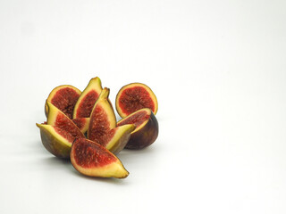 Fresh, juicy figs cut into different pieces on a white background