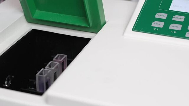 a test tube with bio material is inserted into a device for chemical analysis