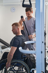 Fototapeta na wymiar Young man with handicap doing weight training exercises, pulls cable