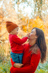 Satisfied mother and daughter, a walk in the autumn forest by the lake