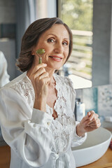 Aging female using gua sha facial roller