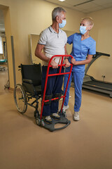 Occupational therapist working with mature man in rehab center