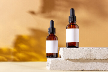 Face and body skin care products in a glass bottle with a pipette on a concrete podium. Cosmetics...