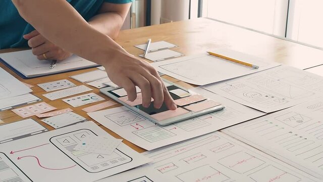 UX or UI designer designing application on tablet with mockup layout prototype.