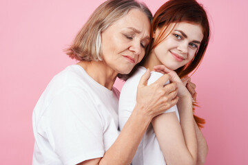 Obraz na płótnie Canvas grandmother and granddaughter close communication together love pink background