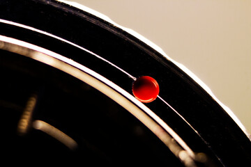 Red dot at the base of a vintage lens in macro image