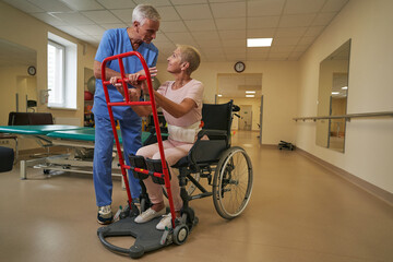 Woman with physical disability uses walking frame indoors