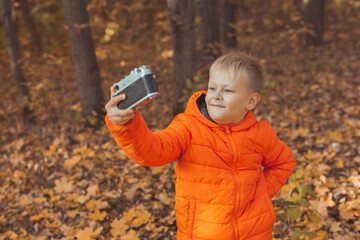 Boy in park in autumn taking selfie photo. Fall and leisure concept.