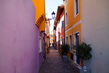 Fototapeta na wymiar colorful quaint houses and narrow streets of the mediterranean town Caorle (North Italy) 