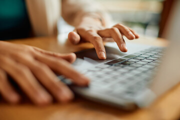 Close-up of businesswoman works on laptop in office.