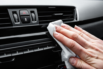 Young woman hands cleaning dust of car by white wet cloth.