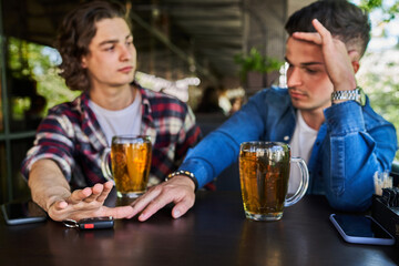 The guys drink beer in the pub, a friend does not allow you to get behind the wheel.