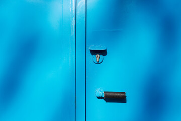 A lock on a blue iron garage door. Close-up. Background. Space for text.