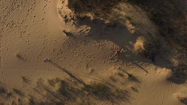 video from a drone, children run to meet mom in the middle of the desert, and mom catches them in her arms