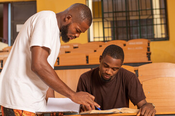 two african students studying in class, discussing school work