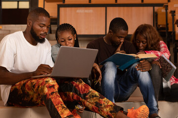 group of african students studying together, sitting on a stair case