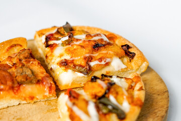 a close up look of the three slices of pizza on the wooden paddle or peel. a tasty Italian baked food with spicy topping on it.