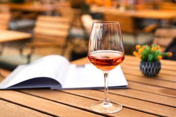 Aperol glass on a table in an outdoor cafe. Vacation and celebration concept. Close-up. Copy space.
