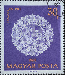 Hungary circa 1960: A post stamp printed in Hungary showing an ornate white halas lace work against a purple background