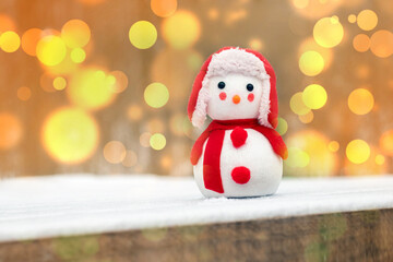 New Year and Christmas greeting card with snowman on blurred background with bokeh