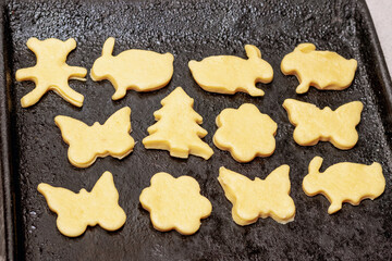 Frying pan with dough in the form of various figures for baking cookies. Making cookies at home