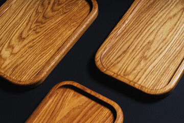 Wooden stylish cutting boards for the kitchen on a black background.