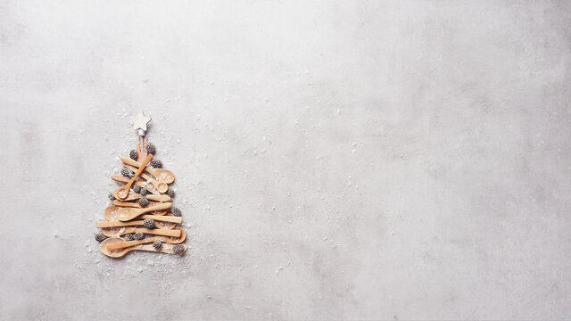 Abstract background with Christmas tree made of wooden spoons and fork with star on top. Top view with copy space.
