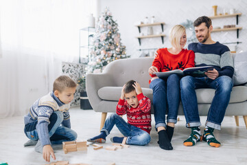 Happy family on the couch near the Christmas tree. Cozy family a