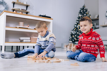 children play on the floor with wooden blocks and toys while parents work.