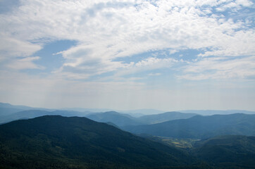 Fototapeta premium Picturesque summer landscape in Carpathian mountains. Lush green forest and cloudy sky. Travel background concept