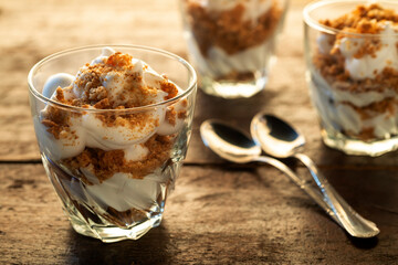 glasses with yogurt and crumbled on wooden table