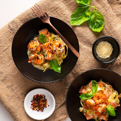 Vista desde arriba de plato de macarrones con salmón en salsa blanca, hongos y queso parmesano para comer con la familia o amigos en el almuerzo o cena