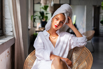 Beautiful woman portrait while wearing red lipstick and turban towel on head while daydreaming in...