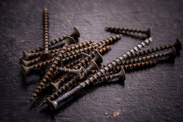 Old screws on a dark background